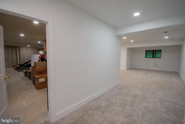 finished basement with baseboards, light colored carpet, and recessed lighting