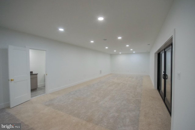 empty room featuring baseboards, recessed lighting, and light colored carpet