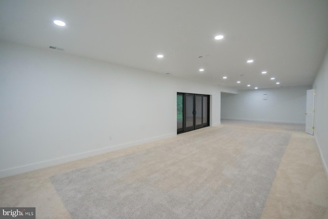 unfurnished room with baseboards, light colored carpet, visible vents, and recessed lighting