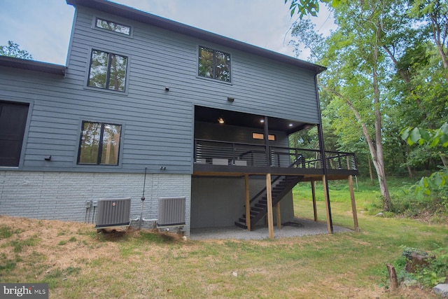 rear view of property with central AC, a yard, a wooden deck, and stairs