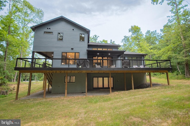 back of house featuring a deck and a lawn