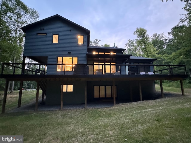 rear view of property featuring a yard and a wooden deck