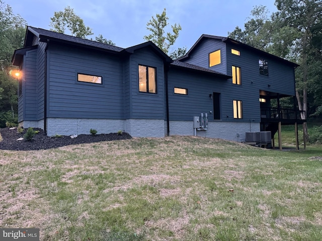 back of house featuring a lawn and a wooden deck