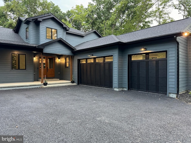 view of front of property with a garage, a shingled roof, and aphalt driveway