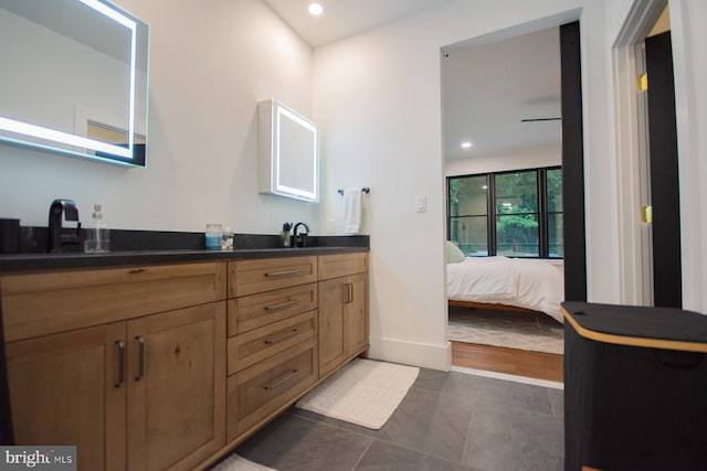 bathroom with double vanity, ensuite bath, tile patterned floors, a sink, and recessed lighting