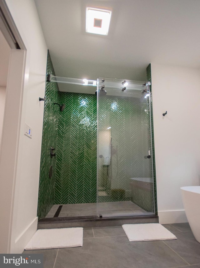 bathroom featuring baseboards, a soaking tub, tile patterned flooring, and a shower stall