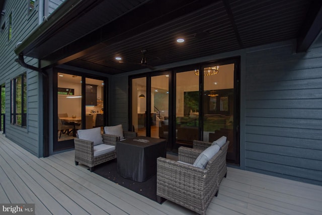 wooden terrace with an outdoor living space with a fire pit