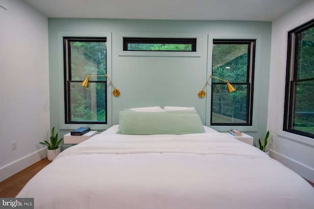 bedroom featuring baseboards and wood finished floors