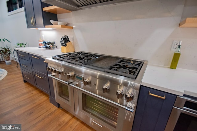 kitchen featuring range with two ovens, blue cabinetry, light countertops, light wood-style floors, and open shelves