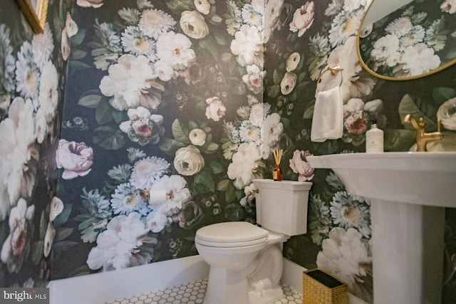 half bathroom featuring tile patterned flooring, toilet, and wallpapered walls