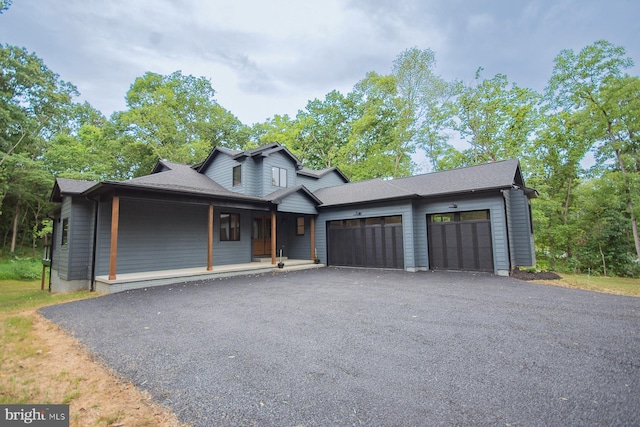 view of front of house featuring a garage, aphalt driveway, and a porch