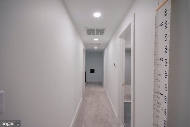 hall with visible vents, light carpet, and baseboards