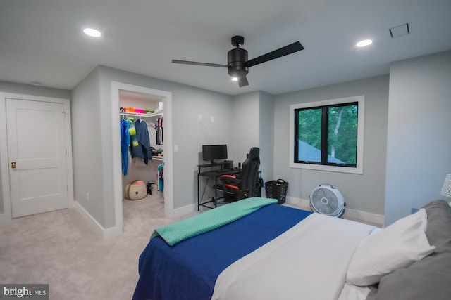 bedroom with recessed lighting, a walk in closet, a closet, and light colored carpet