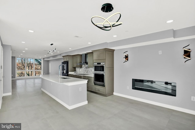 kitchen featuring a sink, stainless steel double oven, recessed lighting, light countertops, and pendant lighting