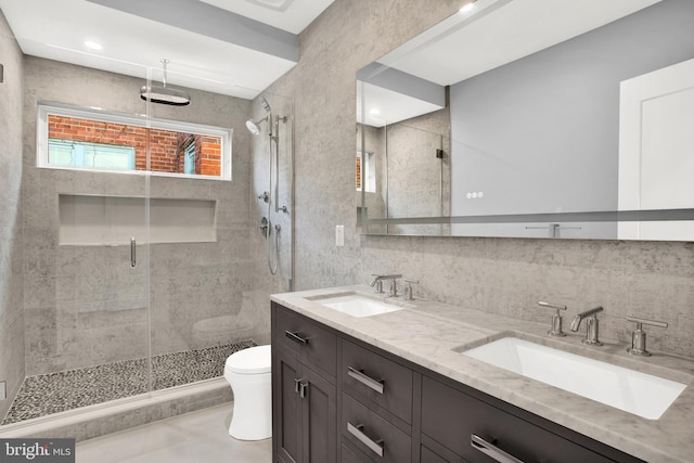 full bathroom featuring toilet, a shower stall, double vanity, and tile patterned floors
