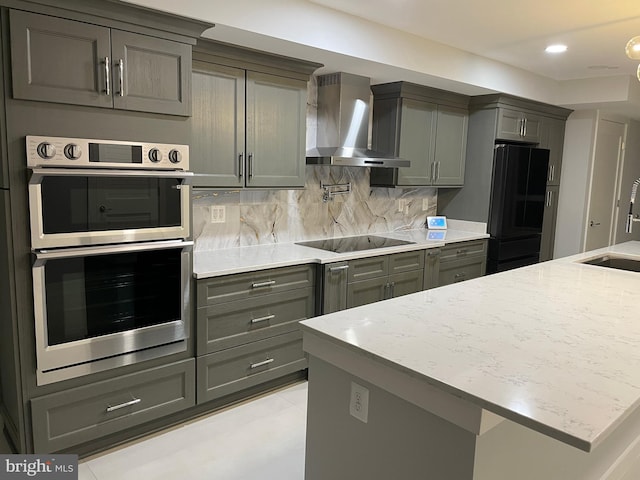 kitchen featuring wall chimney exhaust hood, black appliances, decorative backsplash, gray cabinets, and recessed lighting