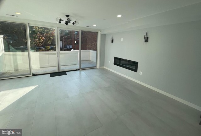 unfurnished living room featuring recessed lighting and baseboards