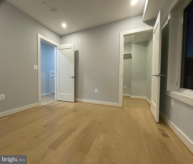 unfurnished bedroom with light wood finished floors, baseboards, and recessed lighting