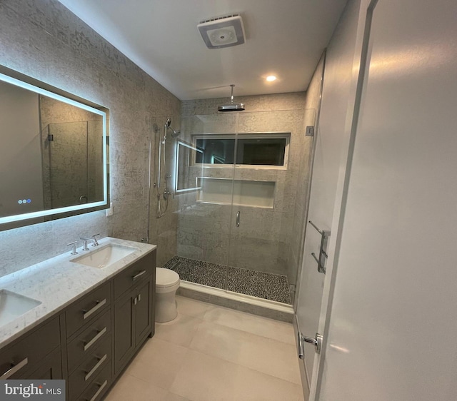 full bath featuring a shower stall, toilet, and double vanity