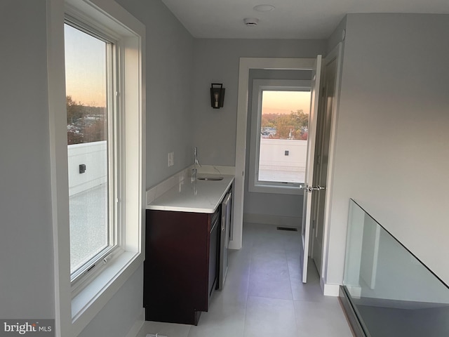 bathroom featuring a sink, tile patterned floors, and baseboards