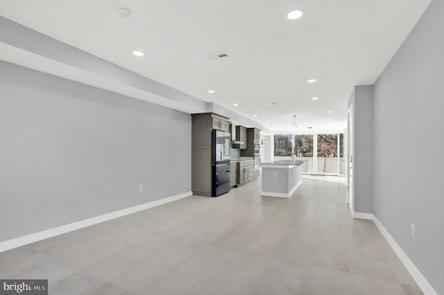 unfurnished living room with recessed lighting, baseboards, and light tile patterned floors