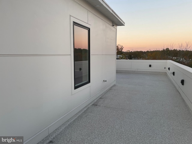 property exterior at dusk featuring a patio