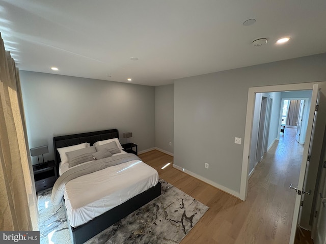 bedroom with light wood-style floors, baseboards, and recessed lighting