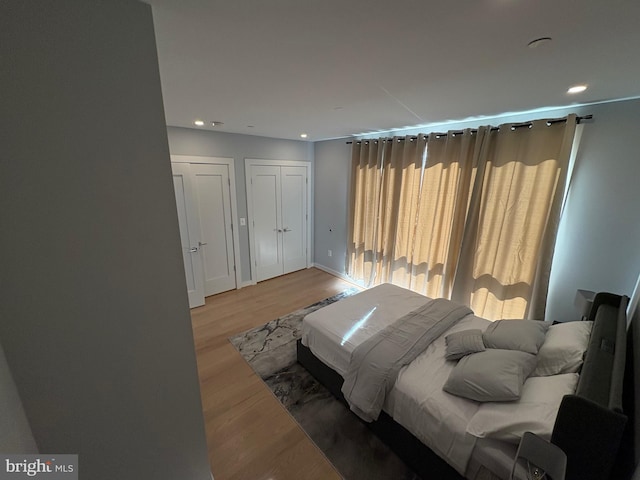 bedroom with light wood-type flooring, recessed lighting, and baseboards