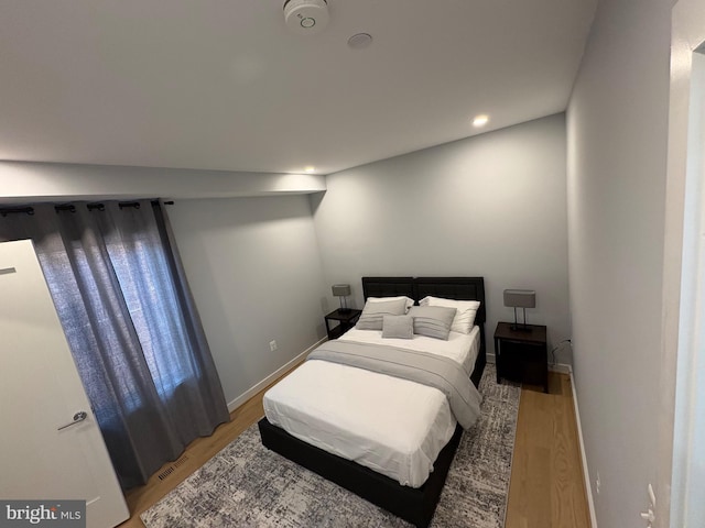 bedroom with light wood-style floors, recessed lighting, and baseboards