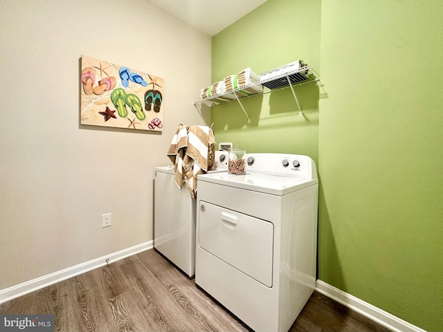 clothes washing area with washer and dryer and wood-type flooring