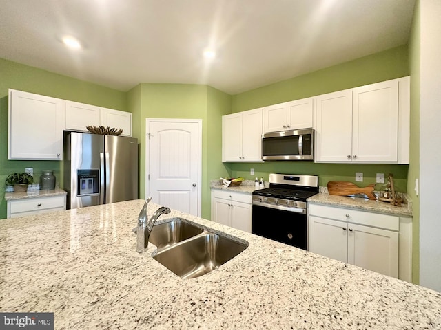 kitchen with white cabinets, light stone countertops, sink, and appliances with stainless steel finishes