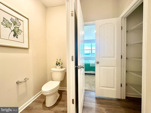 bathroom featuring toilet and wood-type flooring