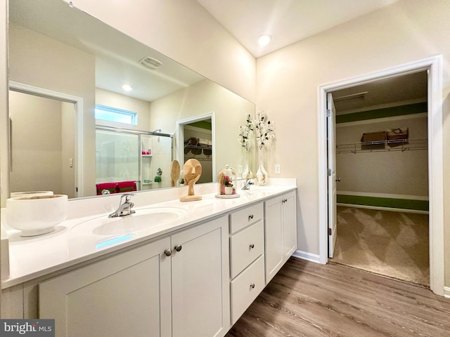 bathroom with vanity, wood-type flooring, and a shower with shower door