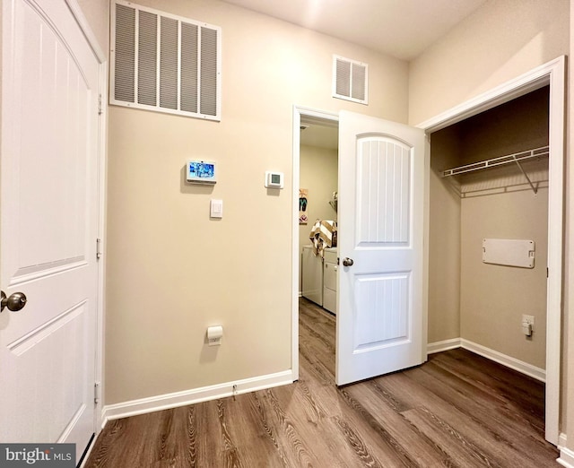 washroom featuring wood-type flooring and washing machine and dryer