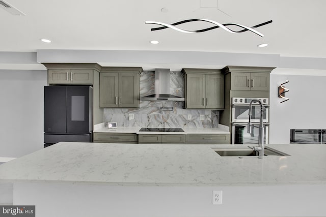 kitchen featuring black appliances, light stone countertops, wall chimney exhaust hood, decorative backsplash, and sink