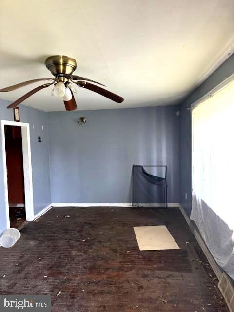 spare room with ceiling fan and dark hardwood / wood-style flooring