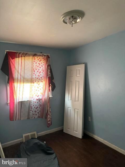 bedroom with dark wood-type flooring