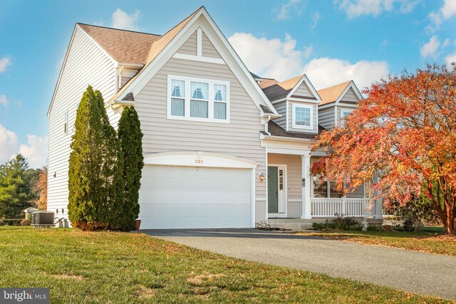 view of front of property with a porch, a garage, and a front yard