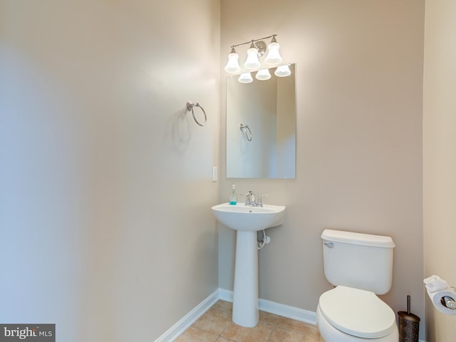 bathroom with sink, toilet, and tile patterned flooring