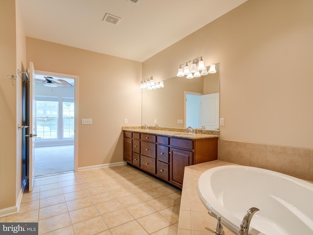 bathroom featuring ceiling fan, tile patterned floors, tiled tub, and vanity