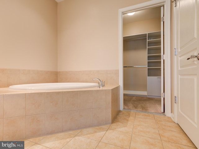 bathroom featuring tile patterned flooring and a relaxing tiled tub