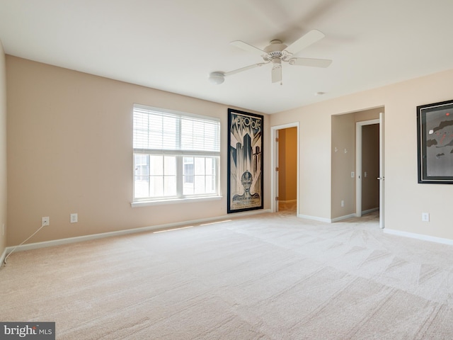 carpeted spare room with ceiling fan