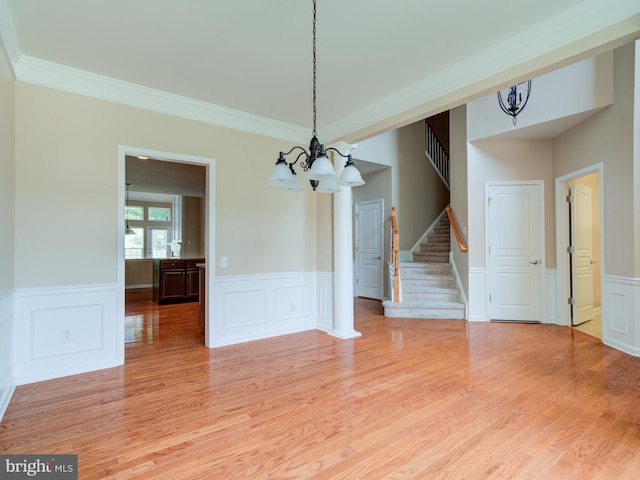 unfurnished dining area featuring crown molding, light hardwood / wood-style flooring, and a notable chandelier