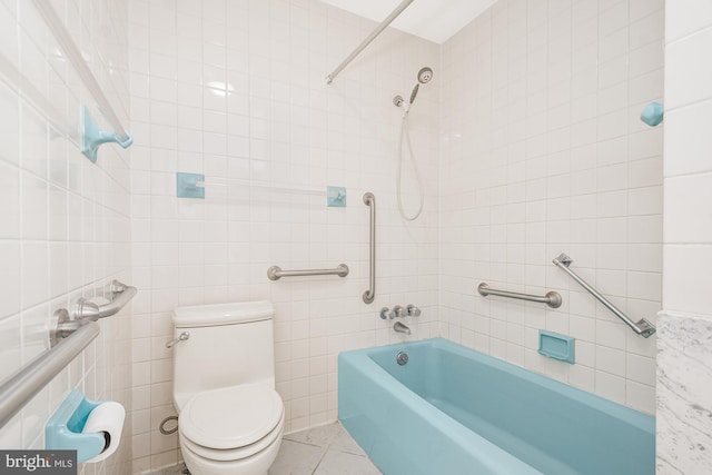 bathroom featuring tile patterned floors, toilet, tile walls, and tiled shower / bath