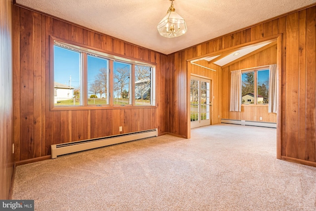 spare room with baseboard heating, a notable chandelier, and a healthy amount of sunlight