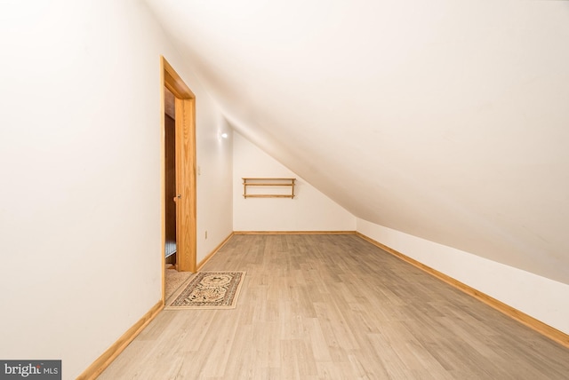 additional living space with lofted ceiling and light wood-type flooring