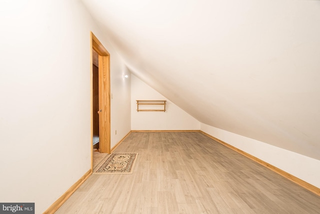 additional living space featuring lofted ceiling and light hardwood / wood-style flooring