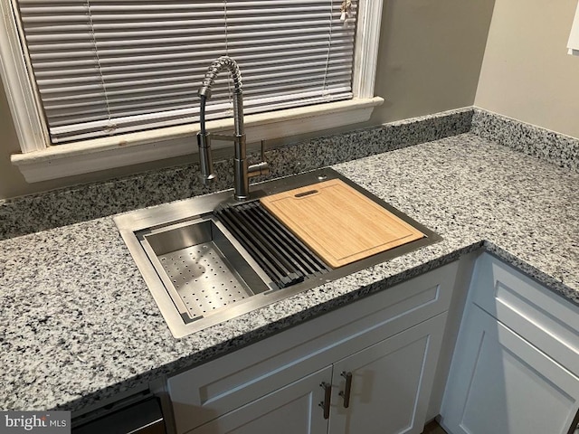 interior details featuring sink, gray cabinets, and stone counters