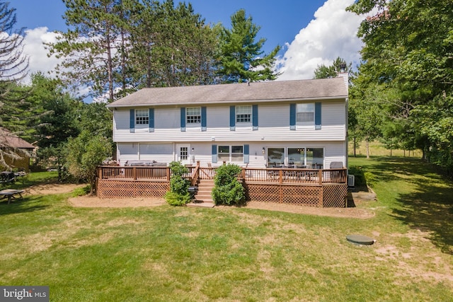 rear view of property with a yard and a deck