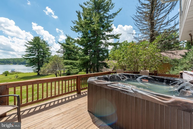 wooden terrace featuring a hot tub and a water view